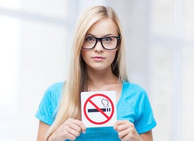 ragazza con un cartello che vieta di fumare all'ingresso
